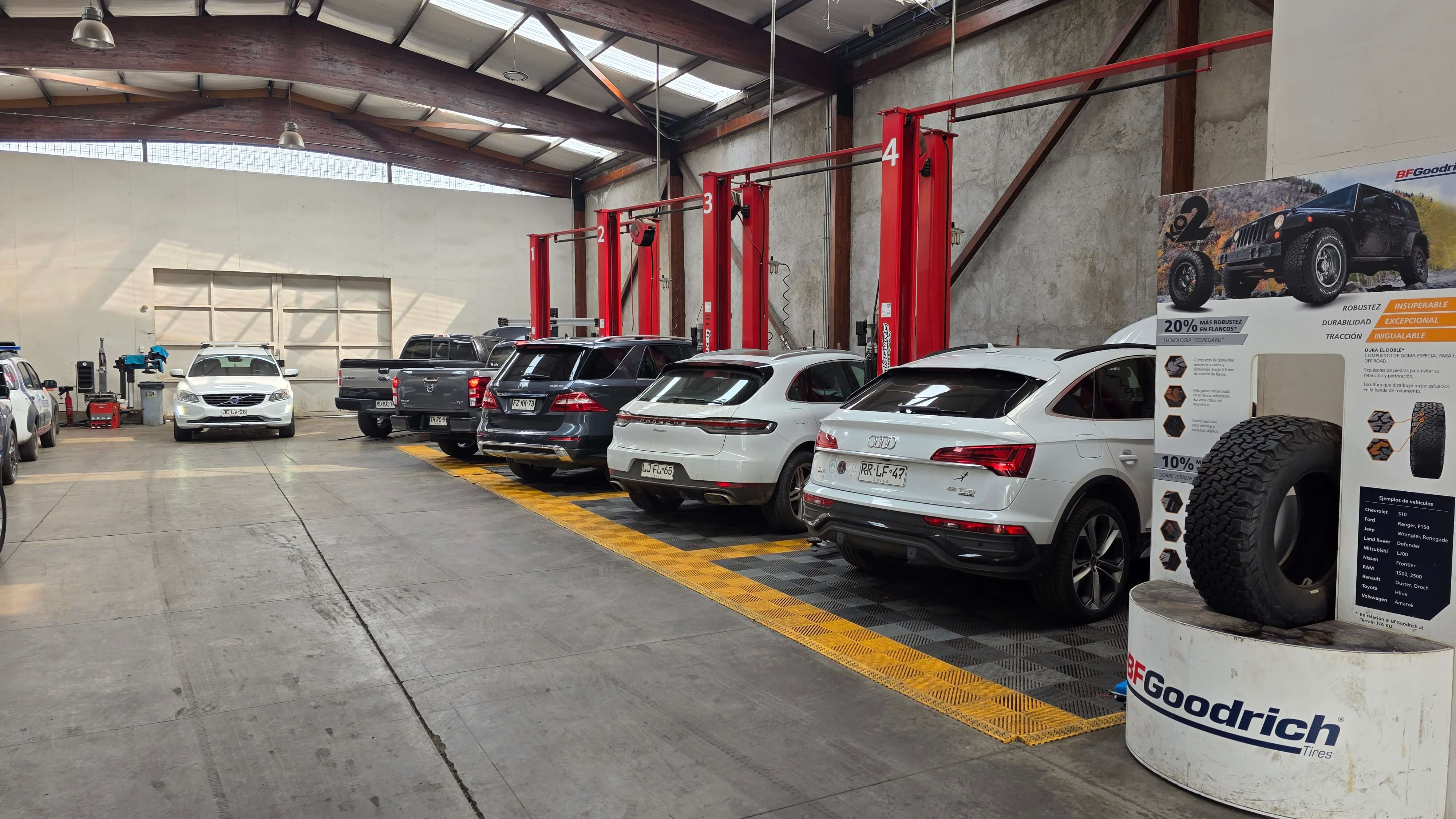 Interior del taller multimarca con vehículos y elevadores hidráulicos