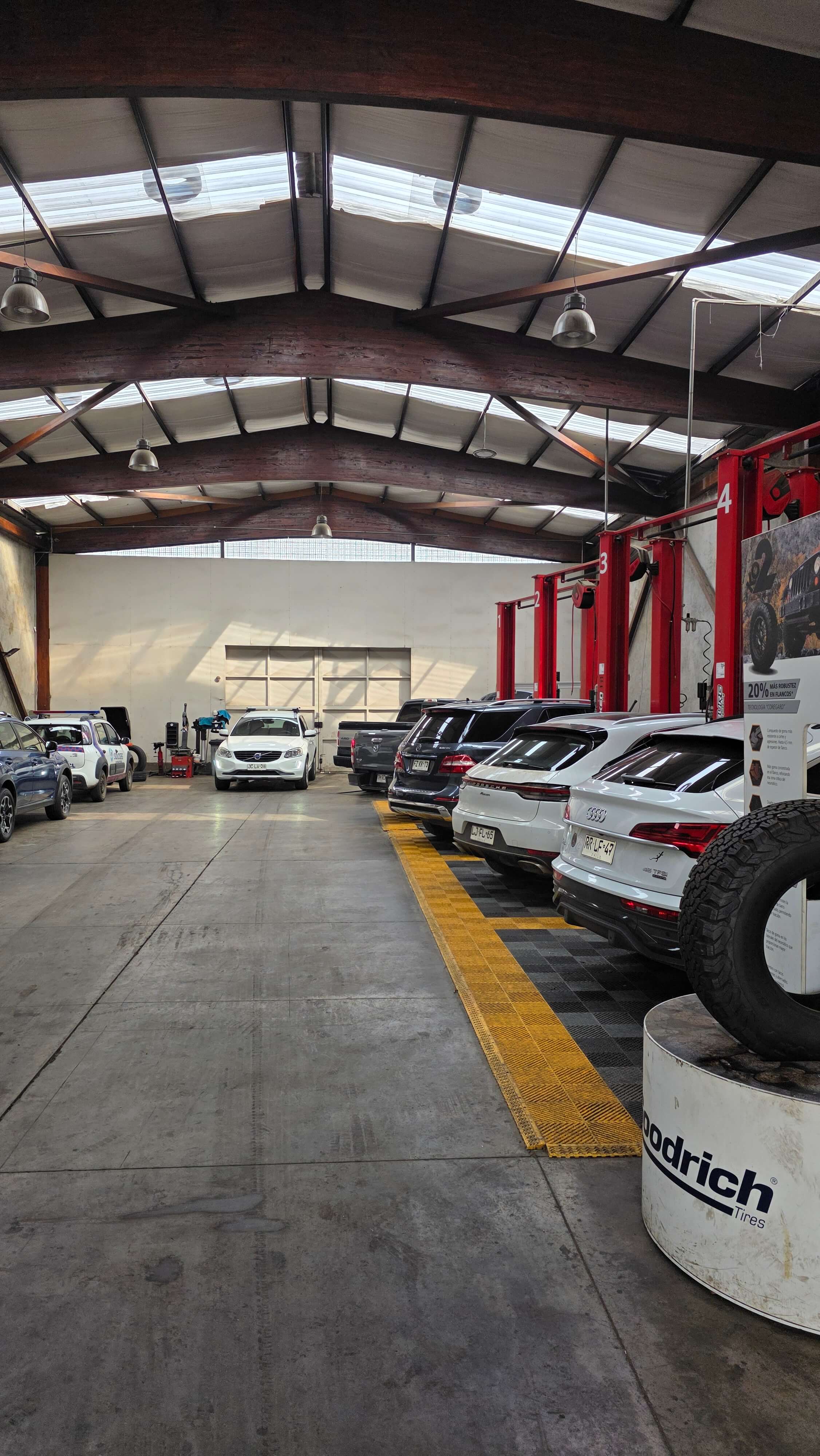 Interior del taller multimarca con vehículos y elevadores hidráulicos